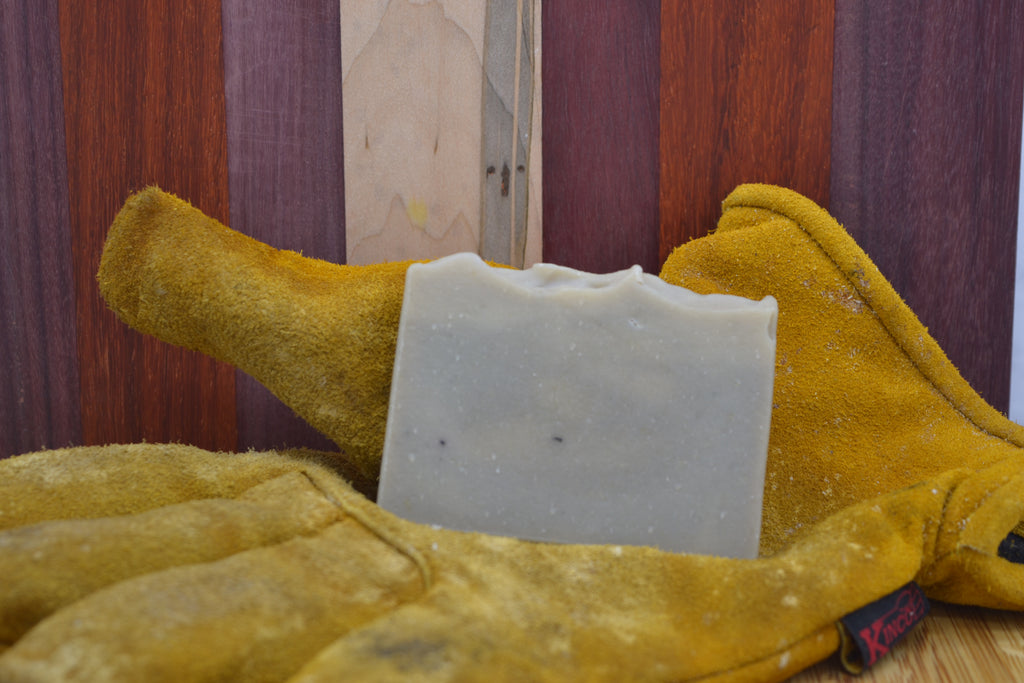 Grey/blue soap bar on a pair of work gloves with a knife for added decoration 