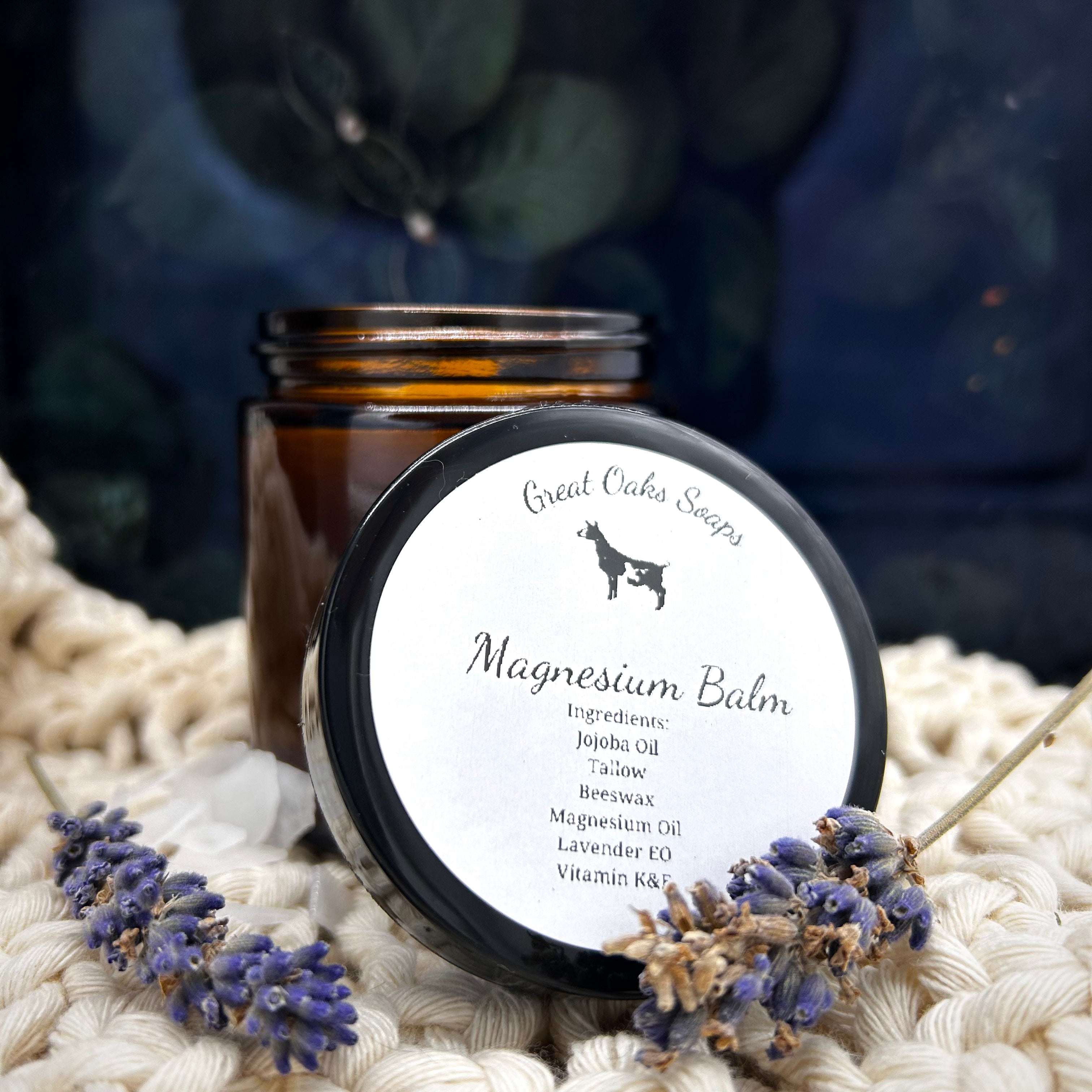 Jar of magnesium balm with a label on a textured surface with lavender flowers.