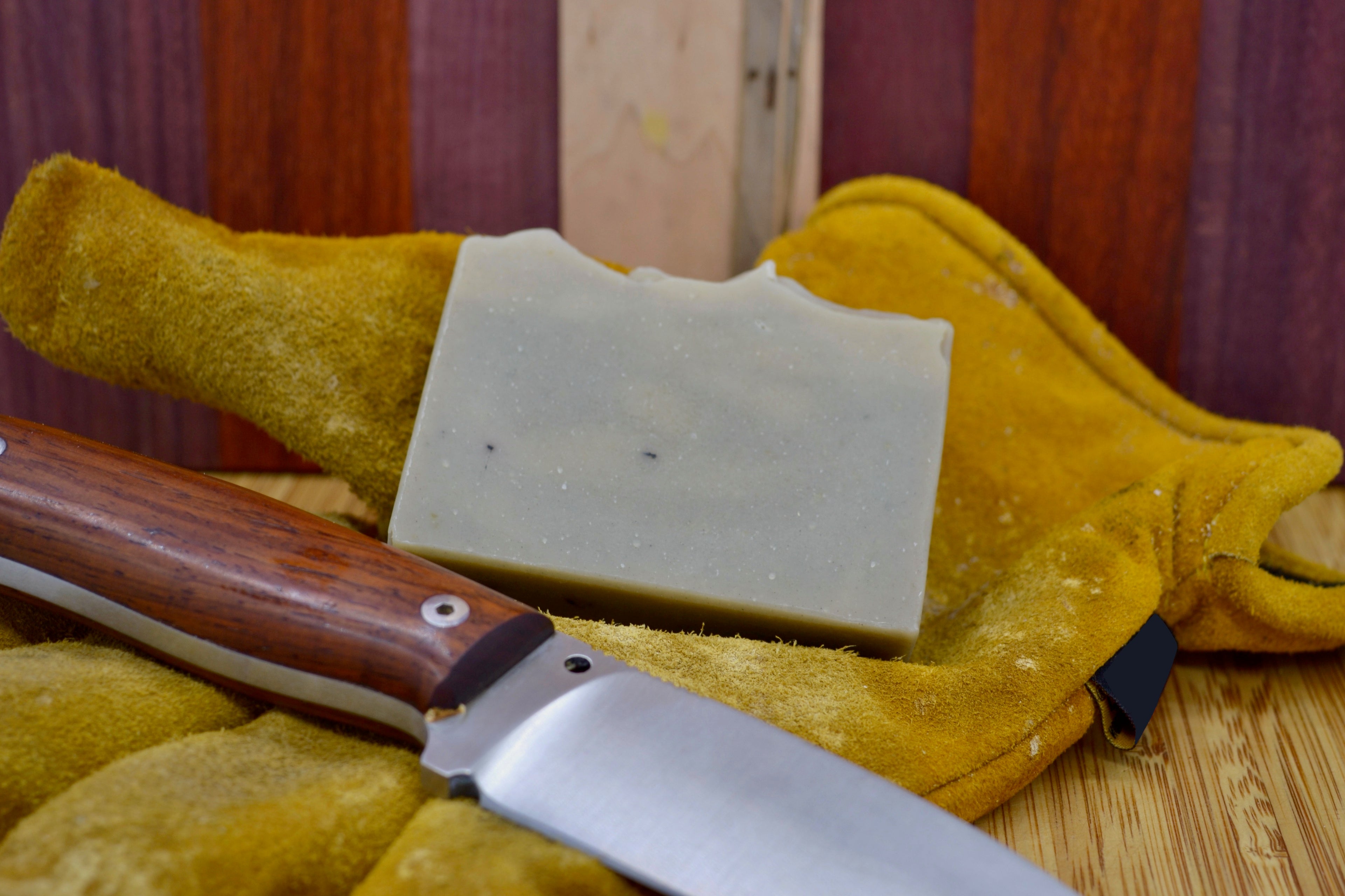 Grey/blue soap bar on a pair of work gloves with a knife for added decoration 